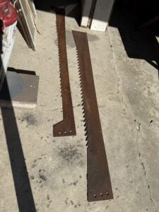 Two rusty saw blades on concrete floor.
