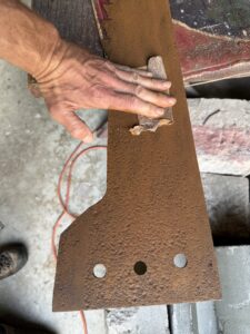 Sanding rust from a metal sheet.