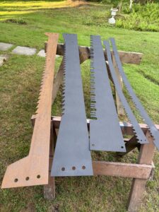 Five large saw blades on wooden table.
