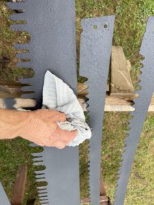 Hand polishing large metal saw blades.