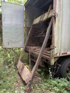 Abandoned truck with open back door.
