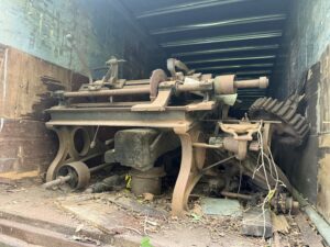 Rusty machinery inside an old wooden container.