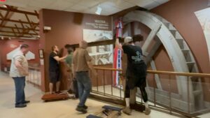 People assembling a large mechanical display indoors.