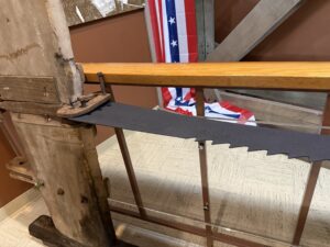 Old sawmill blade with wooden beam.