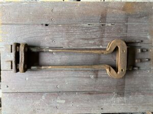 Rusty metal tool on wooden surface.