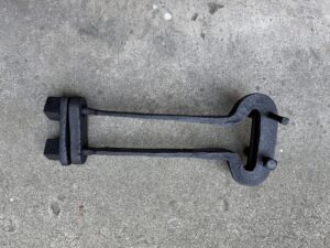 Rustic iron tool on concrete surface.
